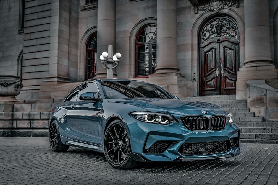 Stylish BMW M2 parked outside a classical building, displaying luxury and elegance